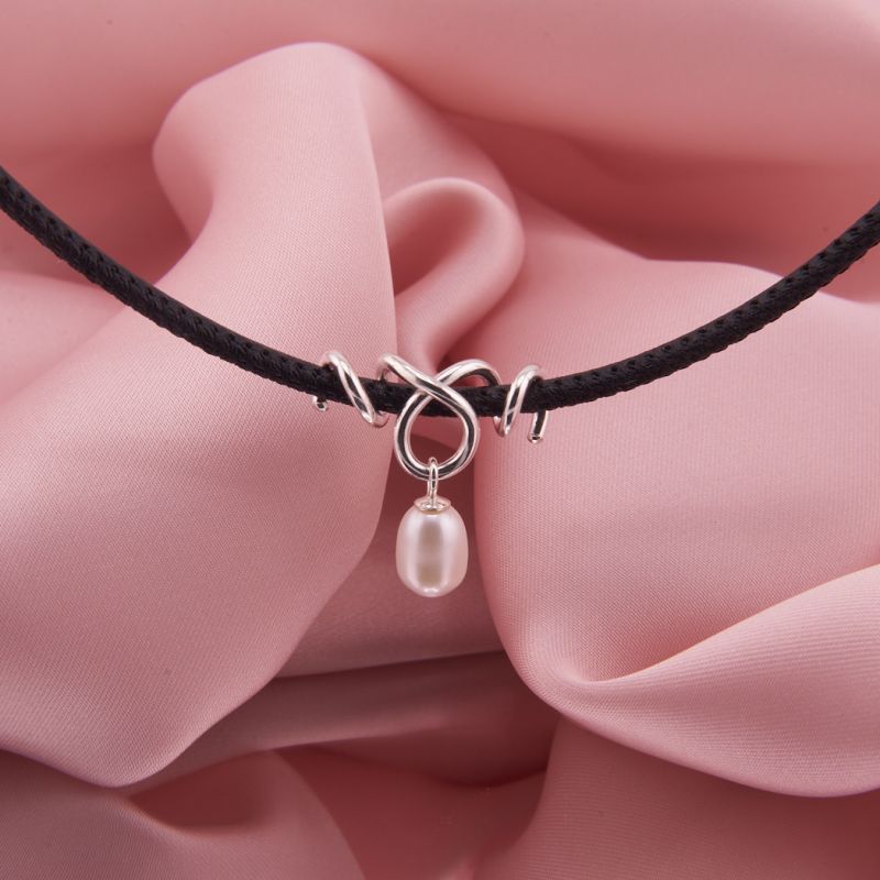 Schwarze Lederkette Remolino mit gewickeltem 925 Sterling Silber Anhänger und einer frei schwingenden, weißen Süßwasserzuchtperle.